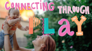 A red-haired mother in profile holds their baby above their head as the baby squeals with delight. The words "Connecting through Play" are spelled out in colorful letters across the image.